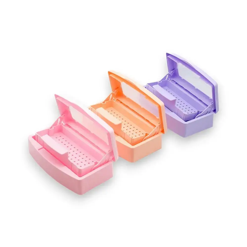 Tres bandejas esterilizadoras plásticas Mely abiertas en colores rosa, naranja y violeta mostrando el sistema de rejilla móvil interna.